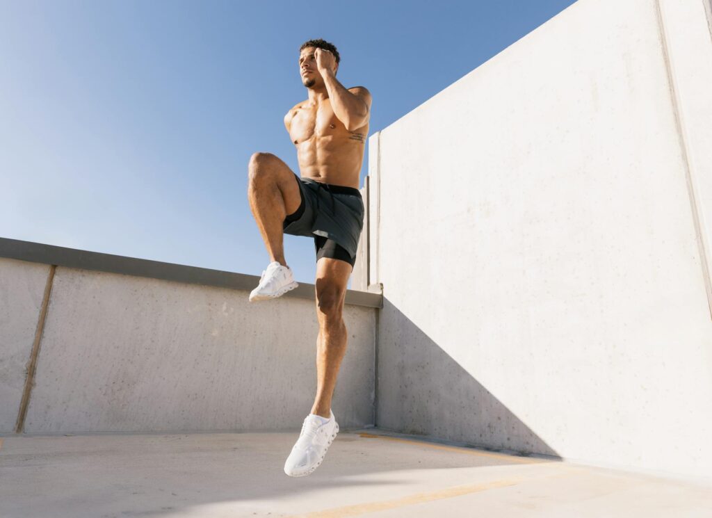 Male athlete doing cardio workout on a rooftop under blue sky in Austin, Texas.